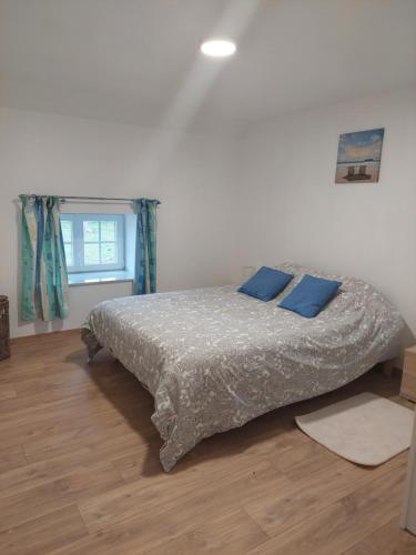 RullyL’Impasse的一间卧室配有一张带蓝色枕头的床。