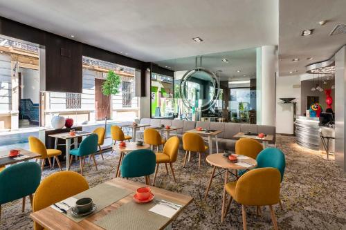 马拉加马拉加马里波萨酒店的一间带桌椅的餐厅和一间酒吧