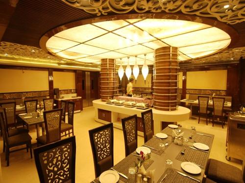 瓦拉纳西科斯塔河酒店的一间带桌椅的用餐室和一间餐厅