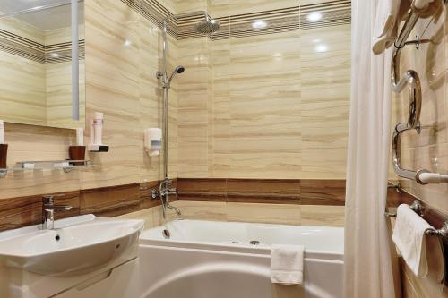 大诺夫哥罗德因图丽斯酒店的带浴缸、水槽和浴缸的浴室