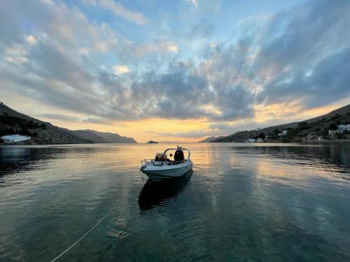 锡米Symi . VILLA CALME (Sur la Mer).的日落时分在水中的小船