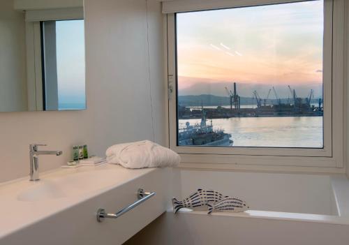 安科纳帕里斯格兰德酒店的浴室设有可欣赏海港景色的窗户。