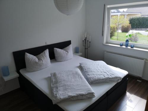 哈亨堡Ferienwohnung Am Philosophenweg的一间卧室配有一张带白色床单的床和一扇窗户。