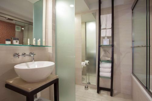 圣胡安圣胡安希尔顿逸林酒店的一间带水槽和玻璃淋浴的浴室