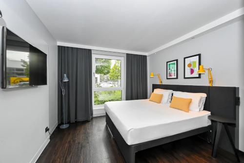 海德堡Staycity Aparthotels Heidelberg的卧室设有一张白色大床和一扇窗户。