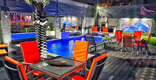 蒂米什瓦拉Villa RICH的一间带桌椅的餐厅和一个游泳池