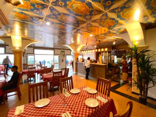 努库阿洛法小意大利酒店的一间带桌子和花卉天花板的用餐室