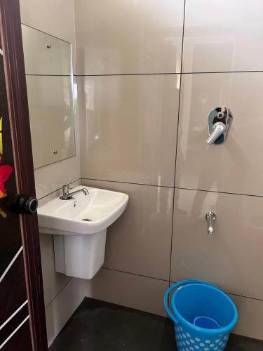 苏丹巴特利Sats residency的一间带水槽、镜子和篮子的浴室