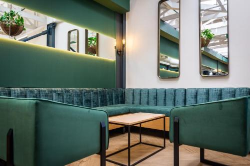 开普敦Old Bank Hotel - Lion Roars Hotels & Lodges的一间设有绿色长椅和桌子的等候室