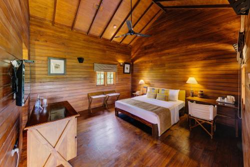 雅拉亚拉辛纳蒙野生酒店的木制客房内的一间卧室,配有一张床