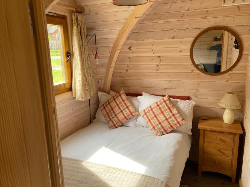 LeightonRabbit Glamping Pod School House Farm的小木屋内一间卧室,配有一张床