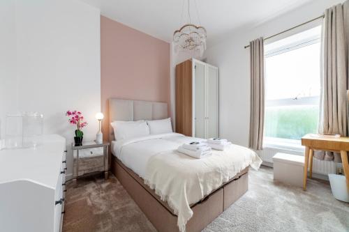 West DulwichFantastic 2BR flat wgarden, West Norwood的一间白色卧室,配有一张床和浴缸