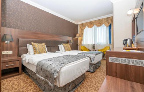 伊斯坦布尔Ma City Hotel的酒店客房设有两张床和电视。