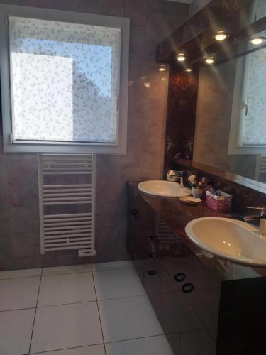 拉罗克德格兰Fan 36B的一间带两个盥洗盆的浴室和一个大窗户