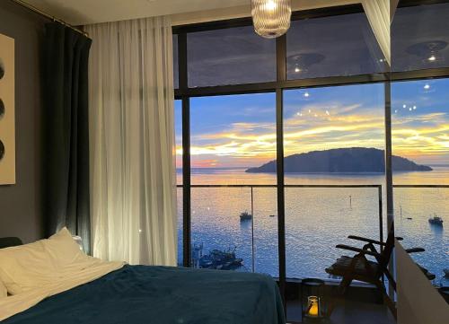 哥打京那巴鲁Seaview Bliss Studio By Tropical Elegance的一间卧室设有大窗户,享有水景