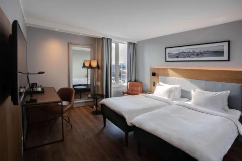 波多博德丽笙布鲁酒店的酒店客房设有一张大床和一张书桌。