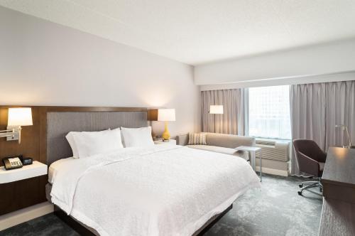 费城费城中心城-会议中心汉普顿酒店的酒店客房设有一张大床和一张书桌。