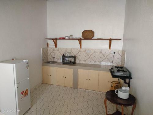 拉穆Manama Suites Apartment的带冰箱和桌子的厨房