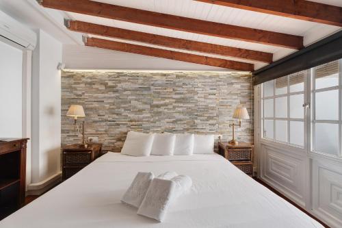 阿德耶Atico 307 Royal Parais Costa Adeje的卧室配有白色的床和砖墙