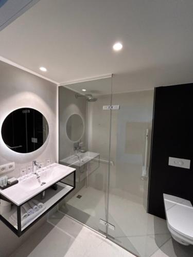 克勒伊斯贝尔亨Hotond Sporthotel的一间带水槽、卫生间和镜子的浴室