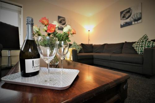 KirkmuirhillSignature - Kirkhill House的桌子上放有一瓶葡萄酒和两杯酒