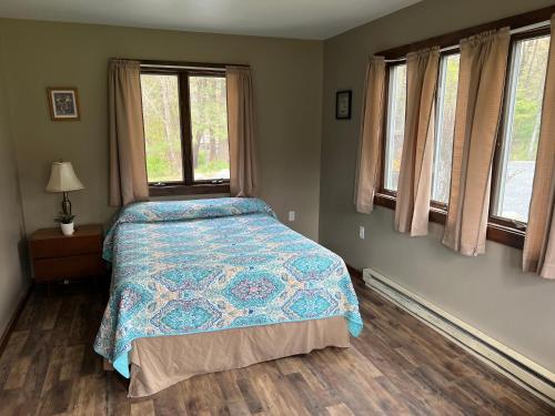 Coolbaugh回音谷度假村的一间卧室配有一张带蓝色棉被的床和窗户。