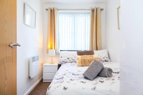 沃灵顿Executive 2 Bed Apartment with Free Parking by Amazing Spaces Relocations Ltd的卧室配有带枕头的床铺和窗户。