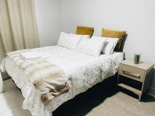 马塞卢Stunning Modern Home in Maseru的一间卧室配有一张床和一个床头柜