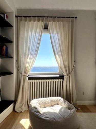 热那亚La Perla di Boccadasse的卧室设有窗户,前面设有一张床