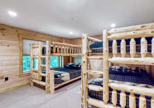 CarrabassettKingslanding Cabin的小木屋卧室配有三张双层床