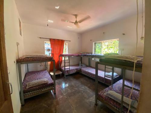 阿姆波尔NamahStay Hostel, Cowork & Artist residency Arambol的一间设有四张双层床的客房