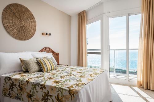 马尔格莱特德玛Hotel Cartago Nova by ALEGRIA的一间卧室设有一张床,享有海景