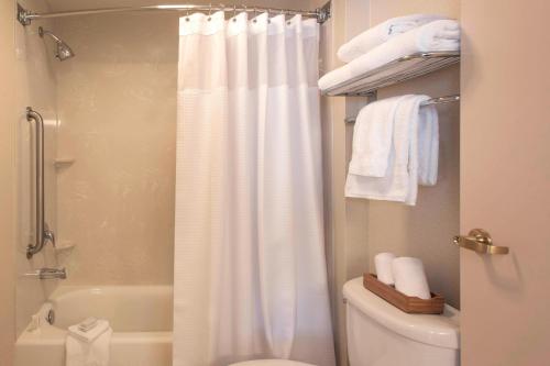 夏洛特夏洛特机场万豪春季山丘套房酒店的浴室配有白色的浴帘和卫生间