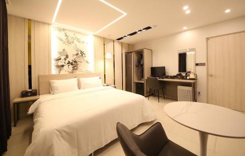 光州Brown Dot Hotel Sinan的一间卧室配有一张床、一张桌子和一张书桌