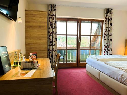 Eresing韦德曼乡村酒店的配有一张床、一张书桌和一扇窗户的酒店客房