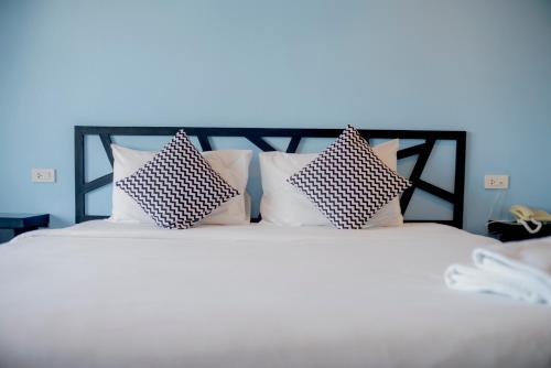 甲米镇睡鲸酒店的一张白色的床,上面有四个枕头