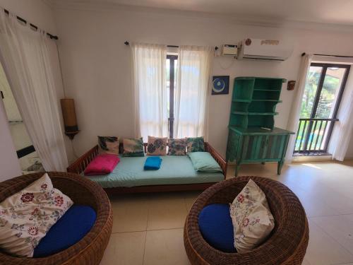 阿伯来Riviera Hermitage Goa的客厅配有2把藤椅和1张沙发