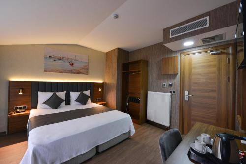 ArnavutköyİSTPORT GARDEN HOTELS的酒店客房设有一张大床和一张书桌。