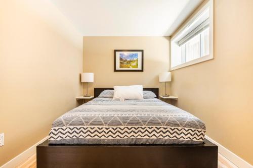 班夫Cougar Street Mountain Rental的一间卧室配有一张床和两盏灯。