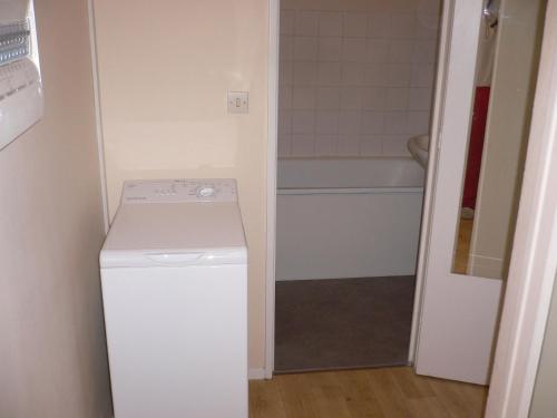 鲁昂Bel appartement meublé et aménagé的一间带洗衣机和浴缸的小浴室