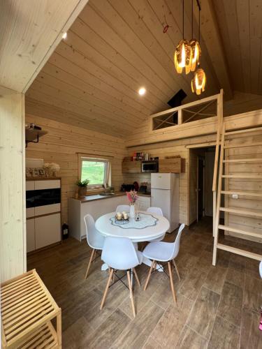 Milkės Karibai - poilsio namelis su sauna ir kubilu的一间厨房和一间带桌椅的小房子的饭厅