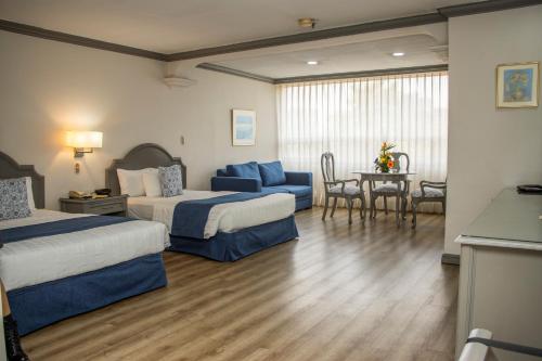 危地马拉桑坦德广场酒店的酒店客房设有两张床和一张桌子。
