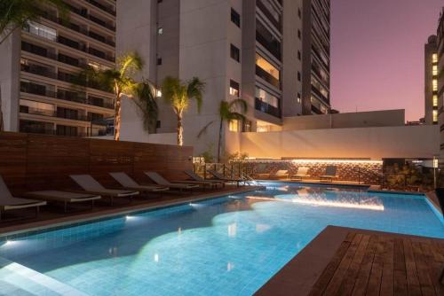圣保罗Apartamento na paulista (com garagem)的一座带椅子的游泳池以及一座建筑