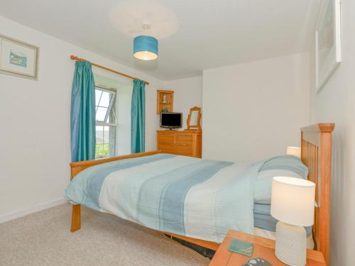 韦德布里奇Primrose Cottage的一间卧室设有一张床、一个窗口和一张桌子