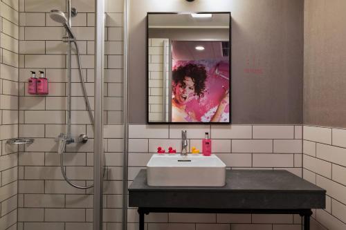 美因河畔法兰克福法兰克福东慕奇夕酒店的一间带水槽、镜子和淋浴的浴室