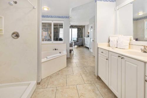 代托纳海滩Luxury 15th Floor 2 BR Condo Direct Oceanfront Wyndham Ocean Walk Resort Daytona Beach | 1501的白色的浴室设有浴缸和水槽。