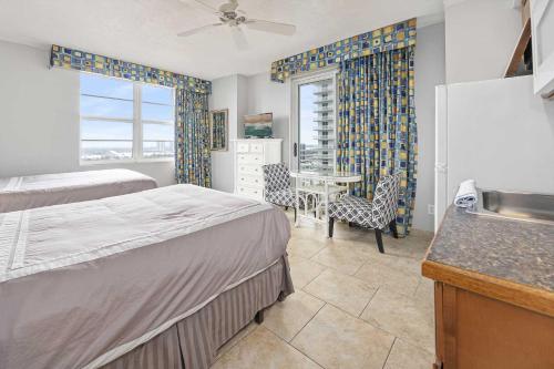 代托纳海滩Luxury 15th Floor 2 BR Condo Direct Oceanfront Wyndham Ocean Walk Resort Daytona Beach | 1501的一间卧室配有两张床和一张桌子及椅子