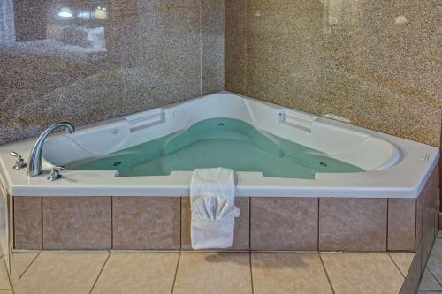 科西卡纳科西卡纳汉普顿酒店及套房的浴室设有装满绿水的浴缸