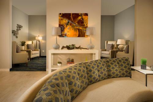 米德兰米德兰希尔顿惠庭套房酒店的客厅配有沙发和墙上的绘画