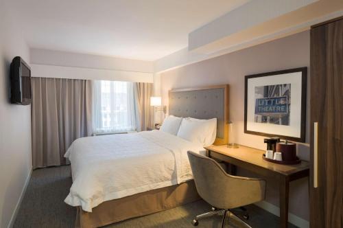 纽约麦迪逊广场花园汉普顿酒店的配有一张床和一张书桌的酒店客房